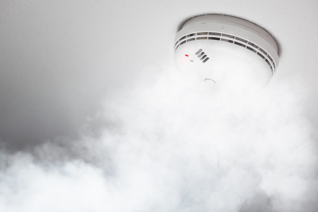 Picture of a smoke alarm with smoke surrounding it 