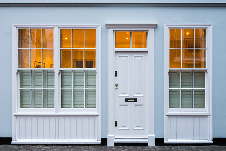 Picture of the front of a house with windows and white painted wall