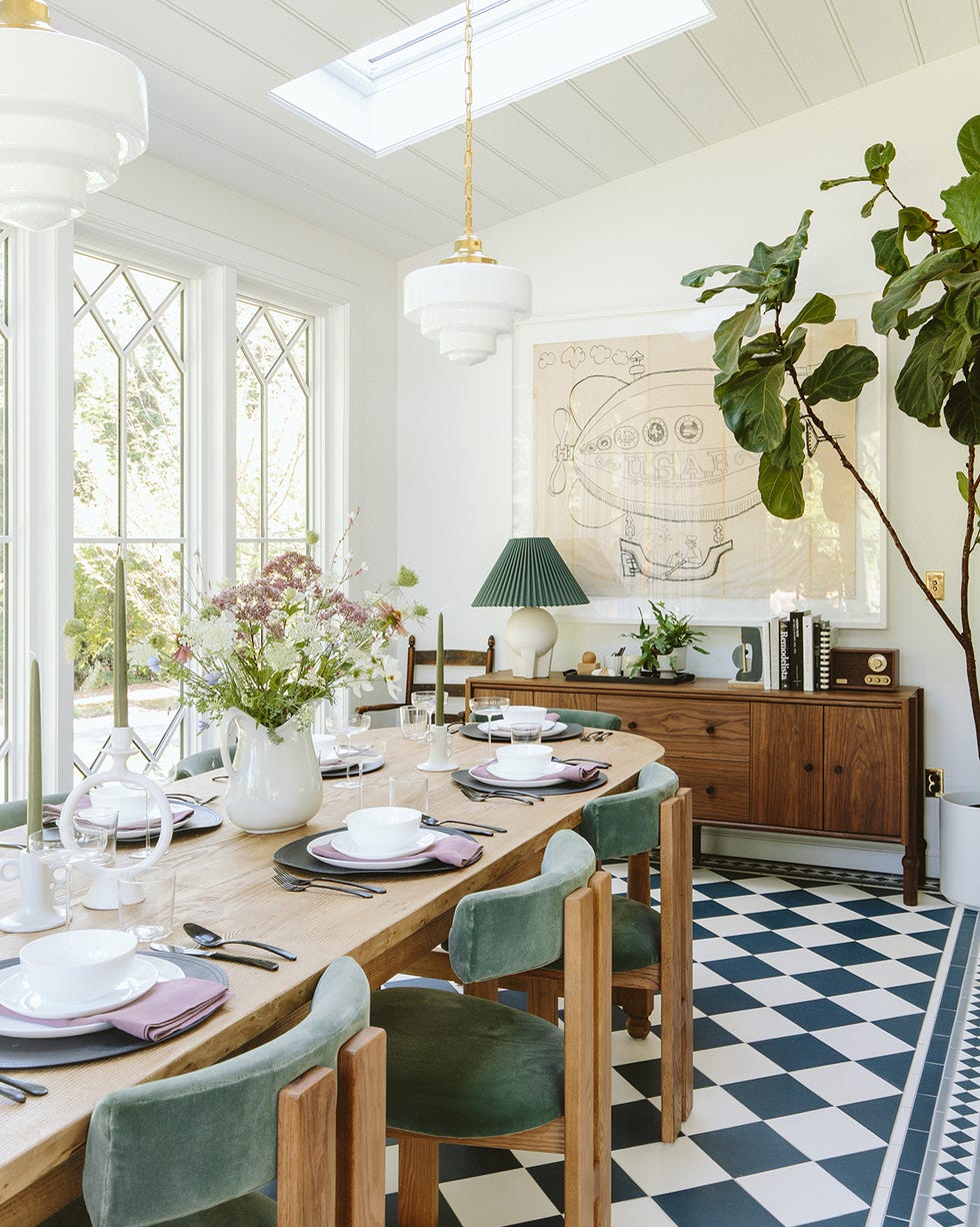 a dining room with a chandelier and a table with plates and cups on it